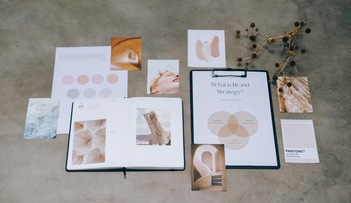 A flat lay of branding elements with color palettes and strategic planning documents on a concrete surface.