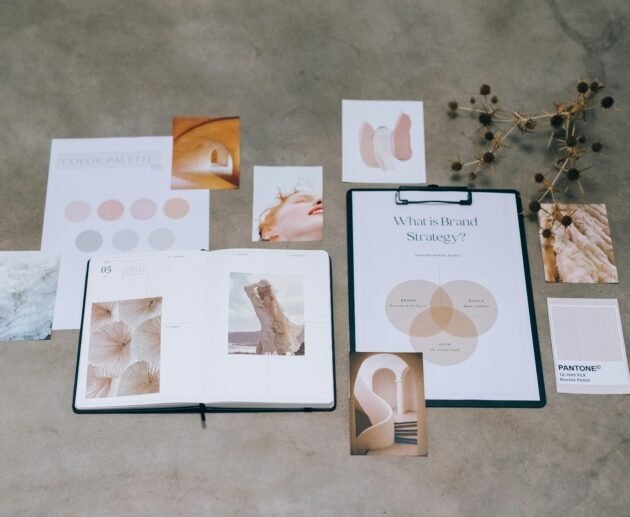 A flat lay of branding elements with color palettes and strategic planning documents on a concrete surface.