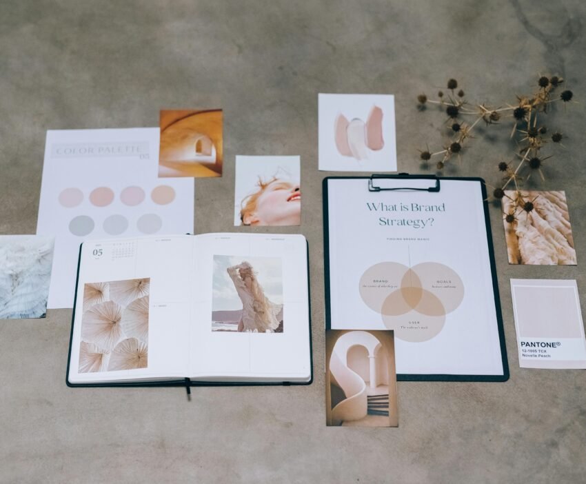 A flat lay of branding elements with color palettes and strategic planning documents on a concrete surface.