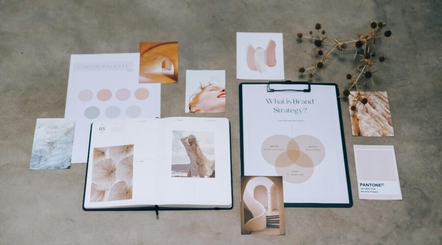 A flat lay of branding elements with color palettes and strategic planning documents on a concrete surface.